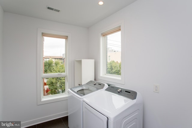 laundry room featuring dark tile patterned flooring, plenty of natural light, and separate washer and dryer