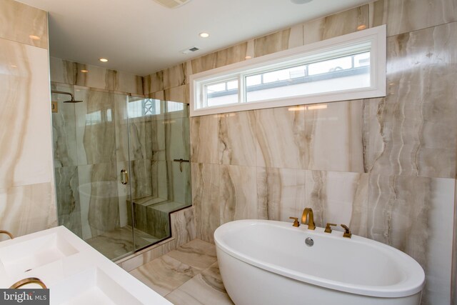 bathroom with independent shower and bath and tile walls