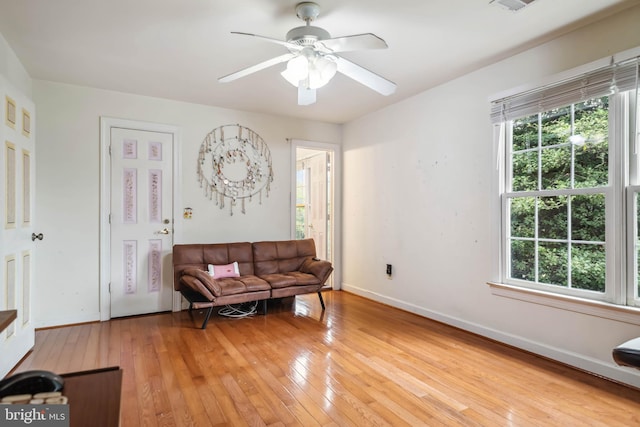 living area with light hardwood / wood-style floors and ceiling fan