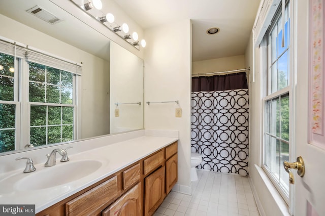 bathroom featuring vanity, tile patterned floors, toilet, and a wealth of natural light