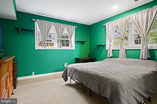 carpeted bedroom with multiple windows