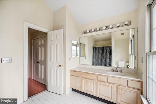 bathroom with a shower with shower curtain, tile patterned floors, vanity, and toilet