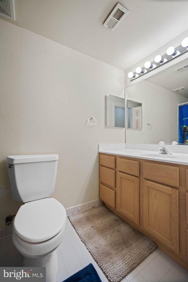 bathroom with tile patterned flooring, vanity, and toilet