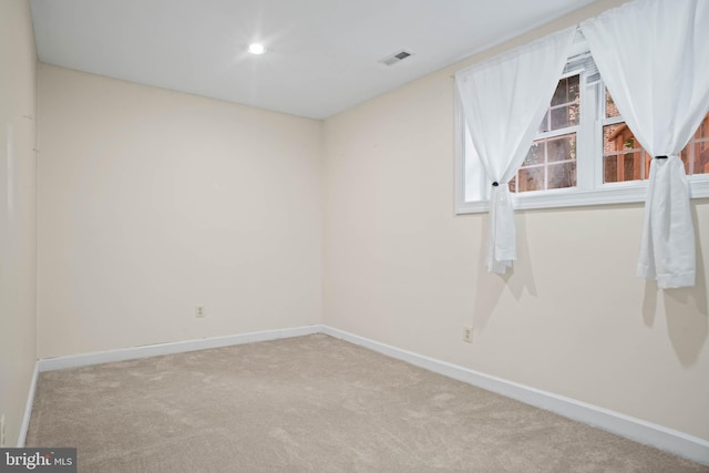 unfurnished room featuring light carpet