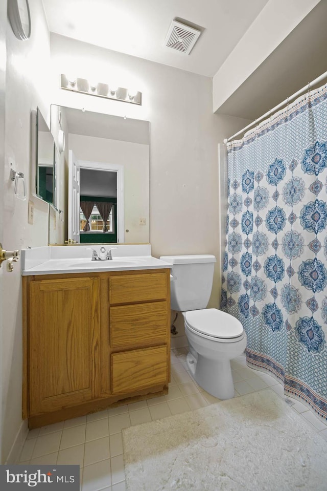 bathroom featuring a shower with shower curtain, vanity, toilet, and tile patterned floors