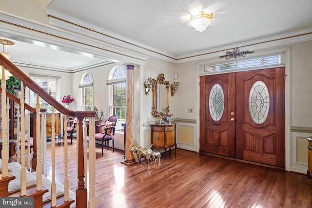 entryway with ornamental molding, hardwood / wood-style floors, and ornate columns