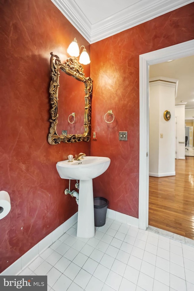 bathroom with wood-type flooring, sink, and crown molding