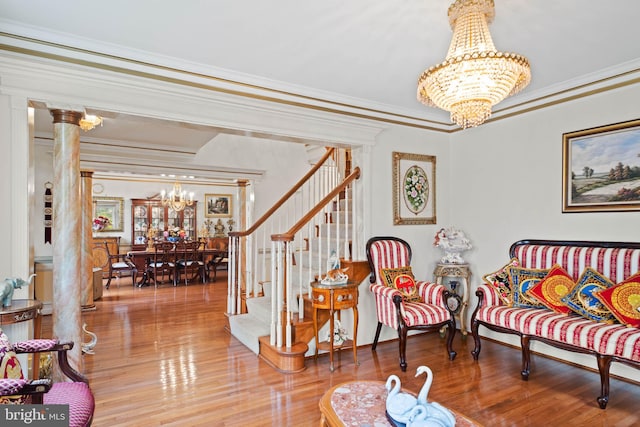 living area featuring wood-type flooring, a chandelier, and ornamental molding