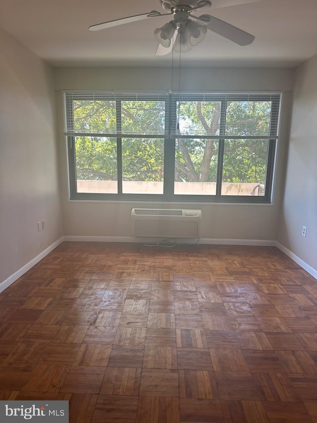 unfurnished room featuring ceiling fan, a wall mounted air conditioner, and parquet flooring