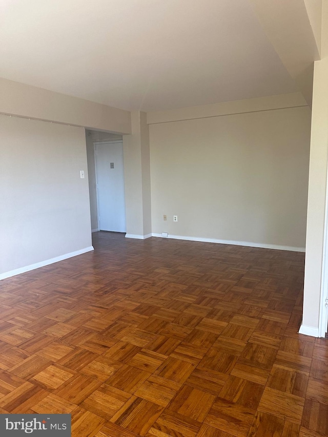 spare room with dark parquet flooring