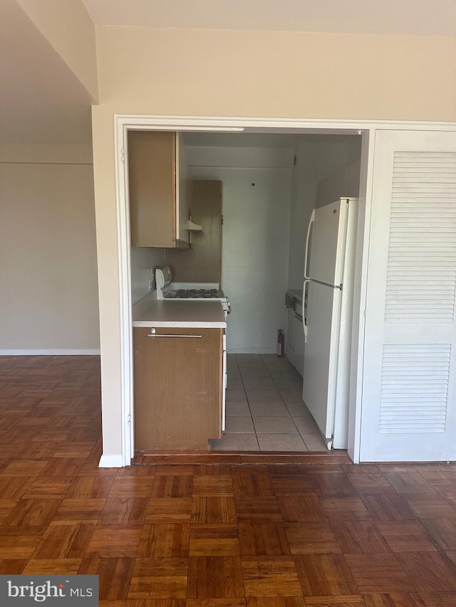 kitchen with dark parquet flooring and white appliances