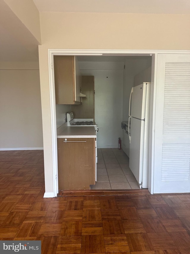 3601 Wisconsin Ave NW Unit 302, Washington, DC 20016 - kitchen with white appliances, light countertops, baseboards, and extractor fan
