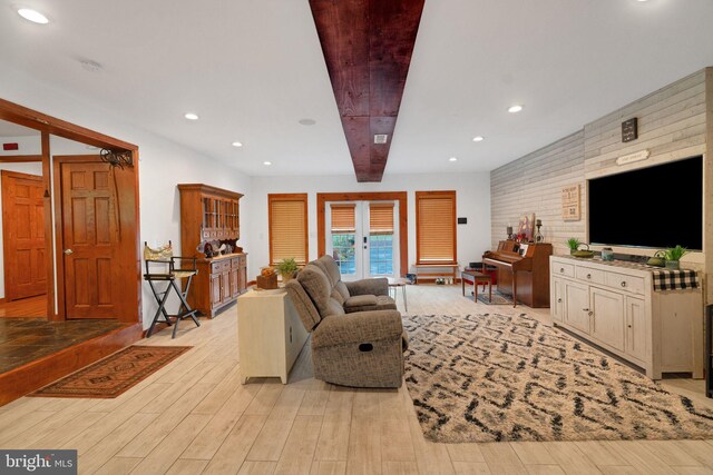 living room with light wood-type flooring, french doors, and brick wall