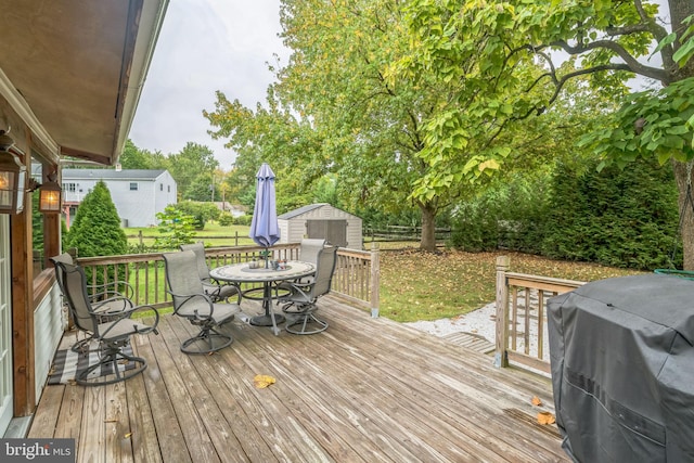 deck with area for grilling and a shed