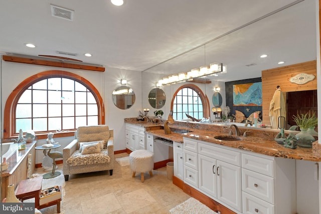 bathroom featuring wooden walls, vanity, and a wealth of natural light