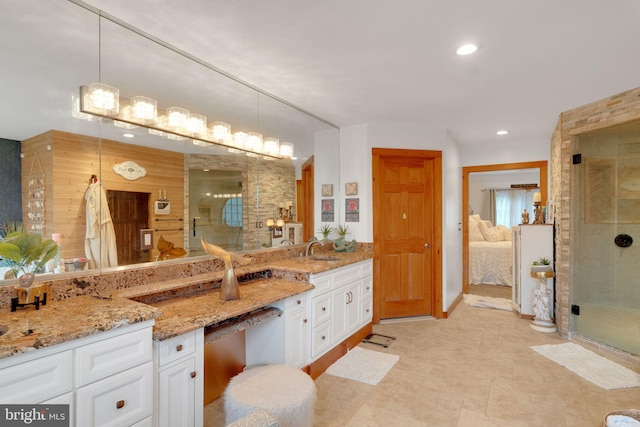 bathroom with vanity and a shower with door