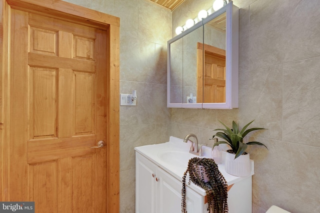 bathroom featuring vanity and tile walls