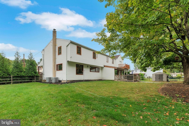 rear view of house with a lawn and a storage shed