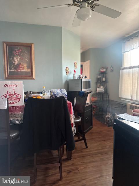 dining space with ceiling fan and wood-type flooring