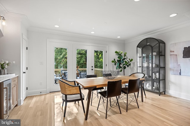 dining space featuring french doors, light wood-type flooring, wine cooler, and ornamental molding