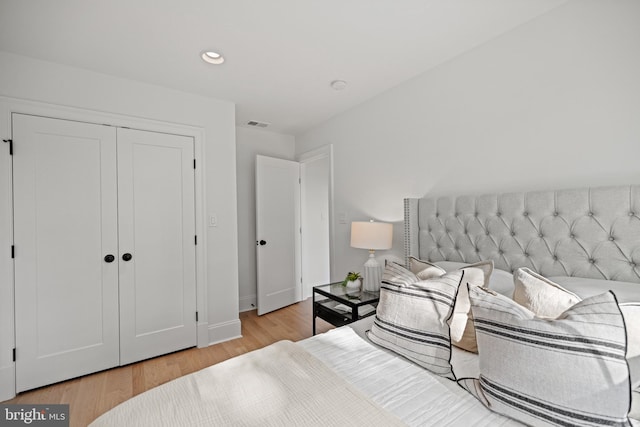 bedroom with light hardwood / wood-style flooring and a closet