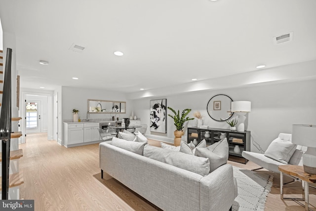 living room featuring light hardwood / wood-style flooring and sink