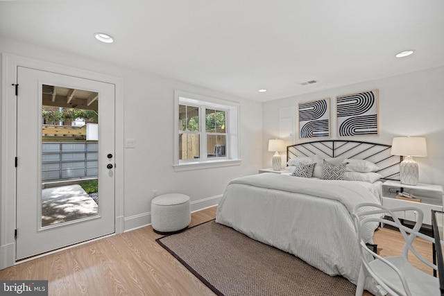 bedroom with access to exterior, light wood-type flooring, and multiple windows