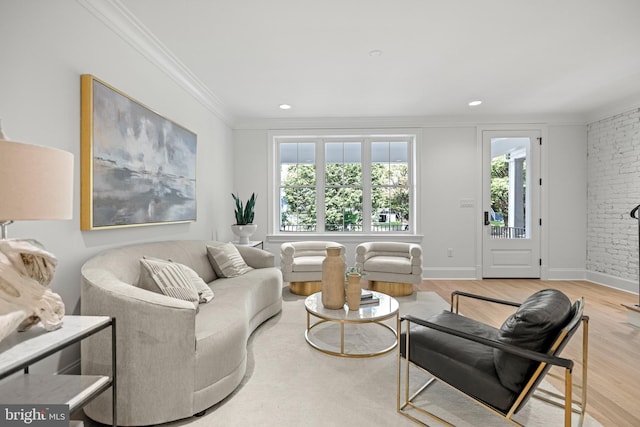 living room with light wood-type flooring, crown molding, and brick wall