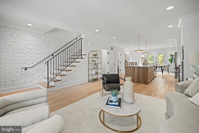 living room featuring light wood-type flooring and crown molding