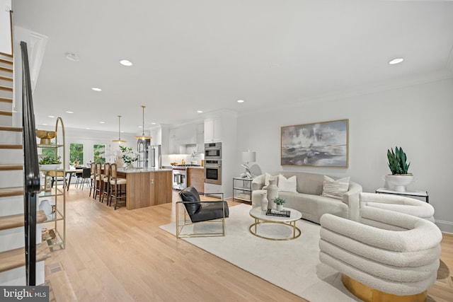 living room featuring light hardwood / wood-style floors and ornamental molding