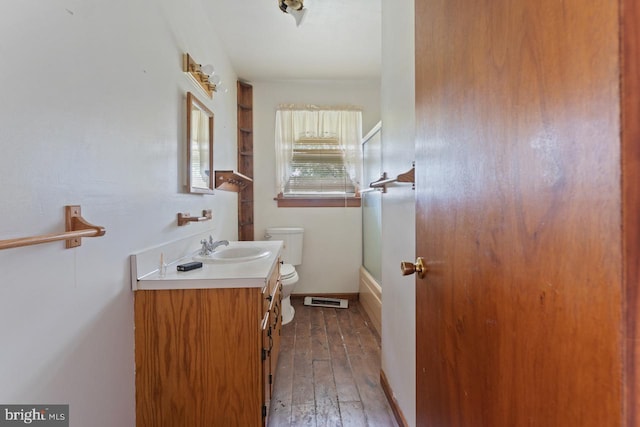 full bathroom with toilet, enclosed tub / shower combo, hardwood / wood-style flooring, and vanity