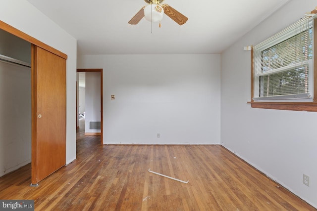 unfurnished bedroom with a closet, hardwood / wood-style floors, and ceiling fan