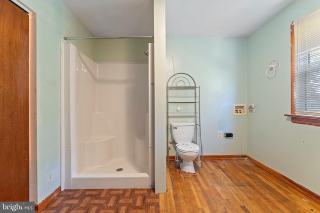 bathroom featuring a shower, wood-type flooring, and toilet