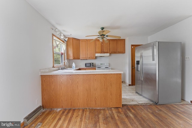 kitchen with kitchen peninsula, sink, light wood-type flooring, appliances with stainless steel finishes, and ceiling fan