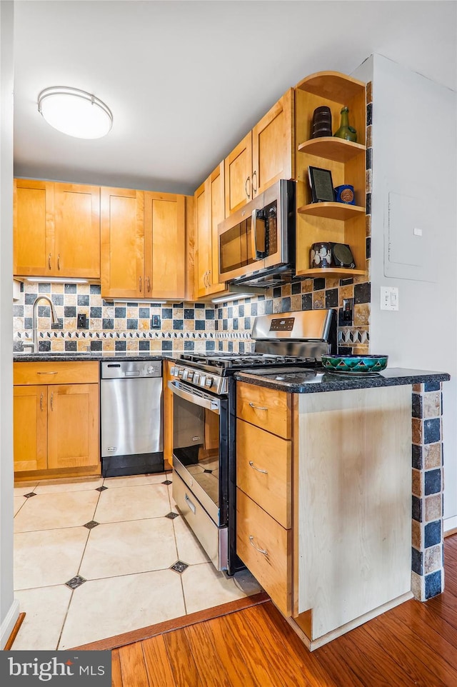 kitchen featuring light wood-type flooring, light brown cabinetry, appliances with stainless steel finishes, and tasteful backsplash