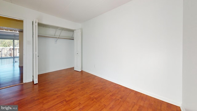 unfurnished bedroom with a closet and hardwood / wood-style floors