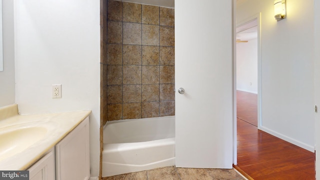 bathroom with a bath, hardwood / wood-style floors, and vanity