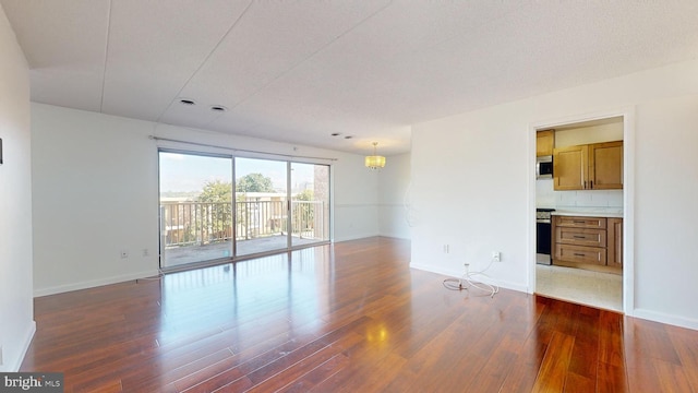 empty room featuring dark hardwood / wood-style floors and a textured ceiling