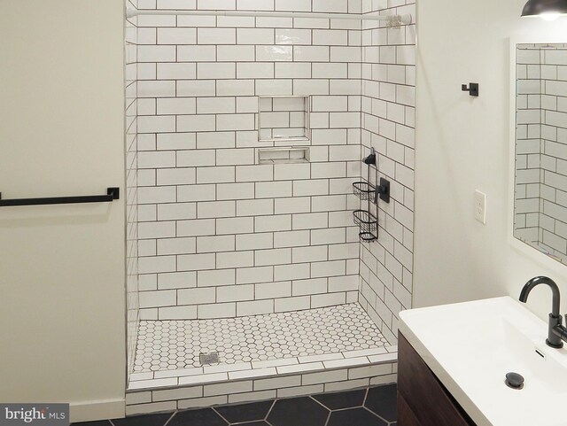 bathroom featuring tiled shower, vanity, and tile patterned floors