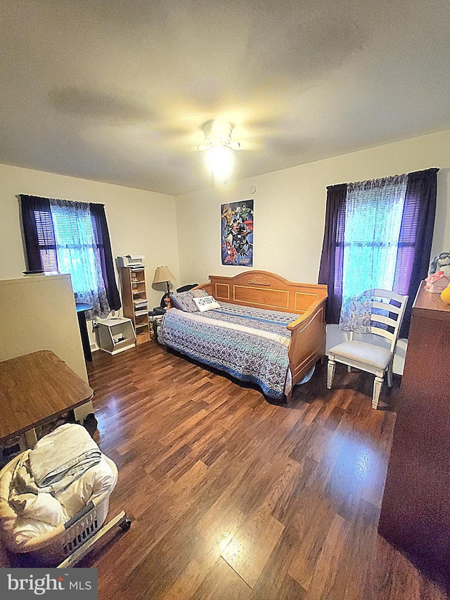 bedroom with dark hardwood / wood-style floors, a textured ceiling, and ceiling fan