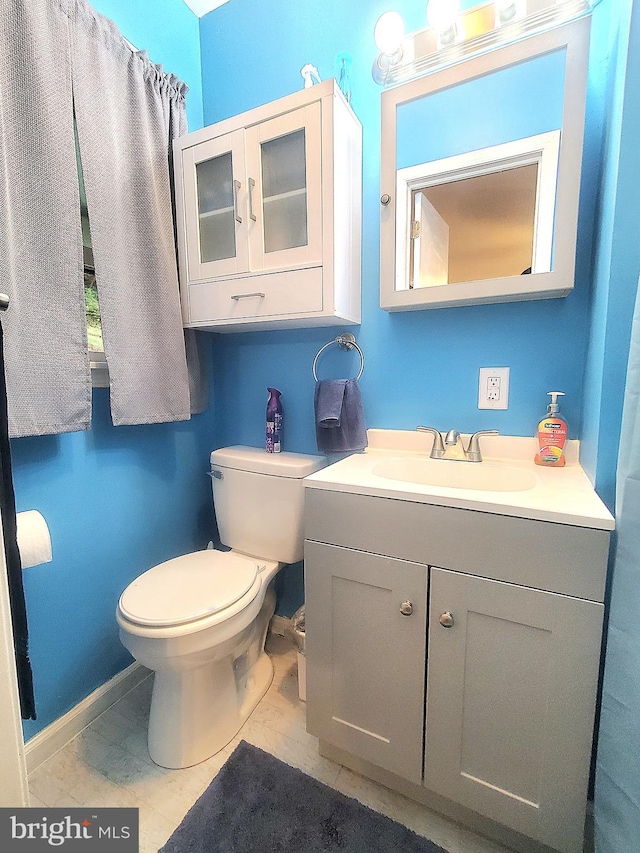 bathroom featuring vanity, tile patterned flooring, and toilet