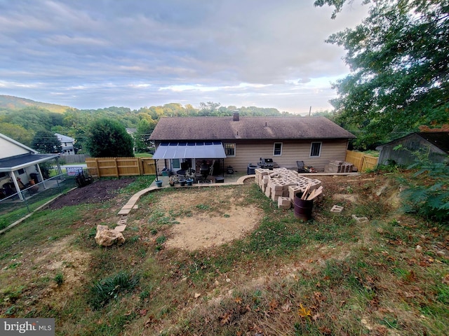 back of property with a mountain view and a patio