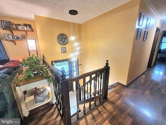 stairway featuring wood-type flooring and a textured ceiling