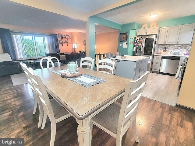 dining area with wood-type flooring and a textured ceiling