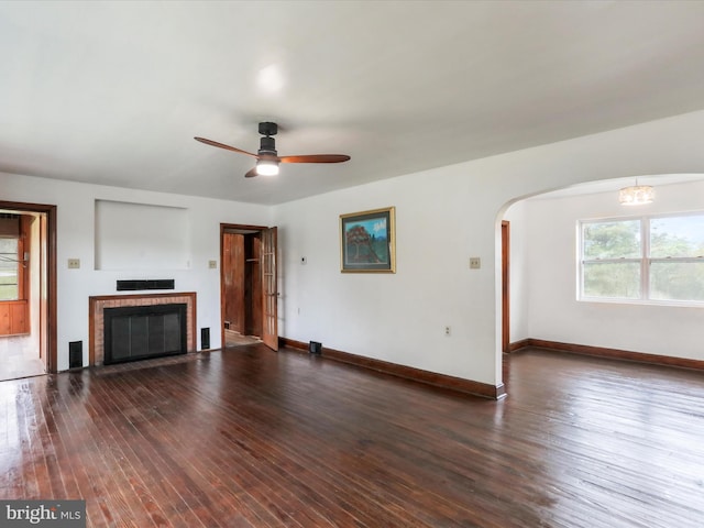 unfurnished living room featuring ceiling fan, a fireplace, and dark hardwood / wood-style floors