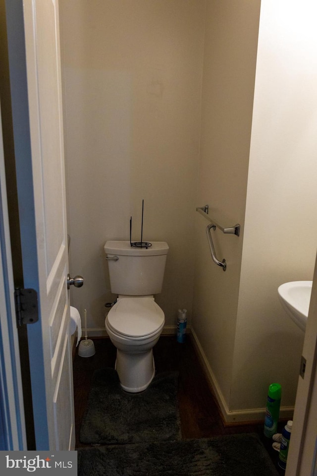 bathroom featuring baseboards and toilet