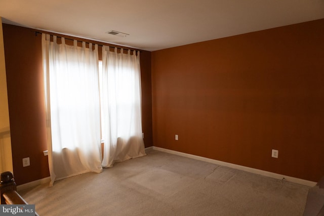 empty room with light carpet, baseboards, and visible vents