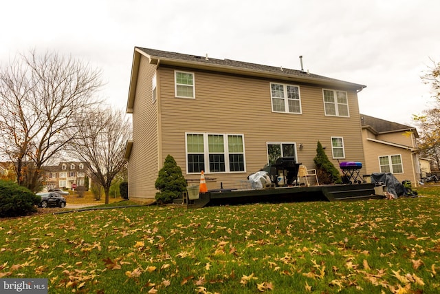 rear view of property with a yard and a deck