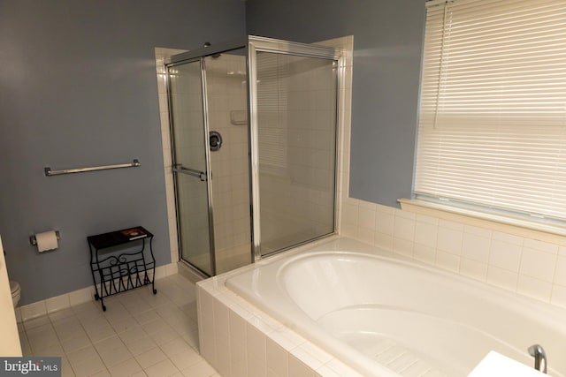 bathroom with toilet, a shower stall, a bath, baseboards, and tile patterned floors