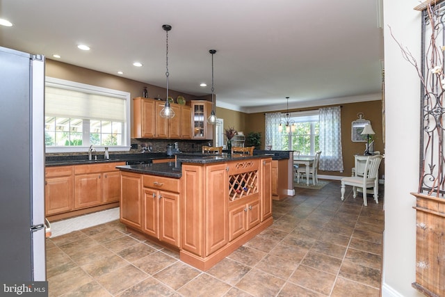 kitchen featuring a wealth of natural light, decorative light fixtures, a center island, and tasteful backsplash